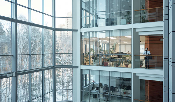 Wide view looking into three stories of glass offices inside a corporate building.