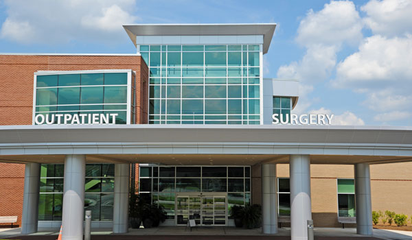 Outside of a hospital entrance with signs reading 