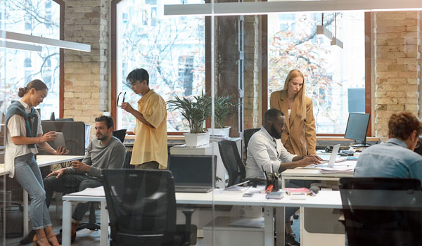 Group of young businesspeople working together in an open-plan office space.